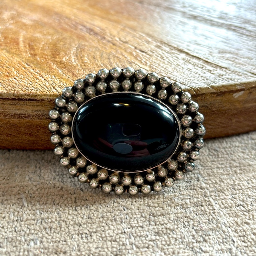 vintage Mexican sterling silver brooch featuring a black onyx cabochon